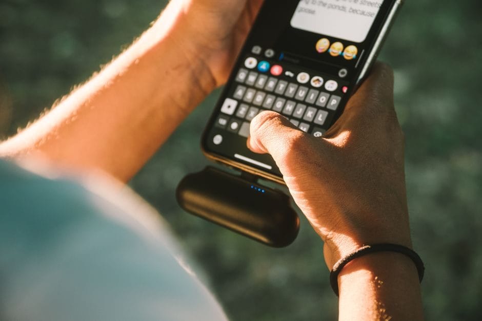 Batterie externe rechargeant un smartphone en extérieur lors d'un festival d'été